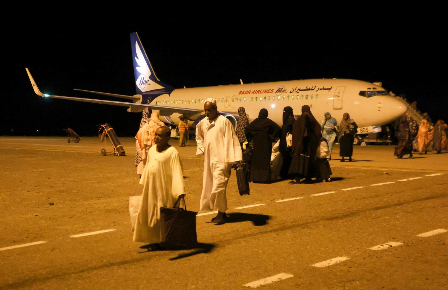 Sudanese people returning from Jeddah walk at Port Sudan International Airport